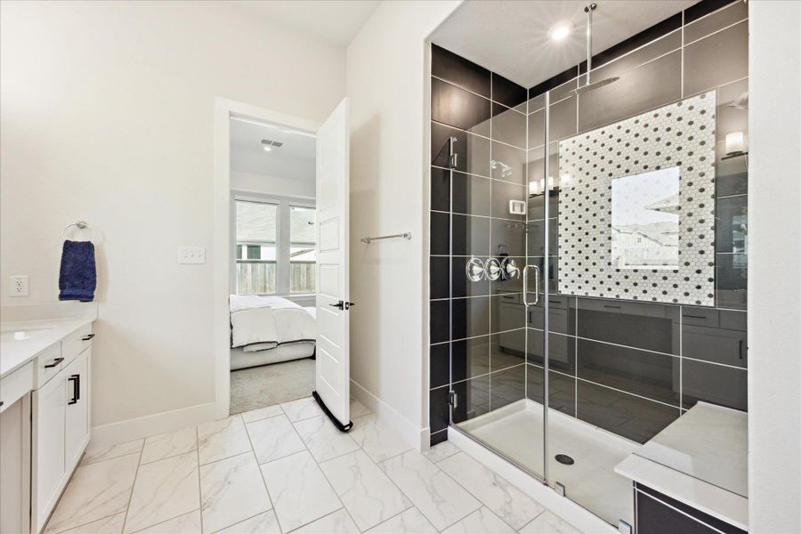 Gorgeous primary bathroom featuring a upgraded shower, marble finish floor, and ensuite bathroom