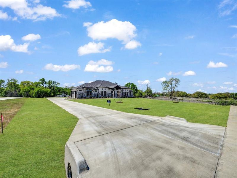 View of front of home with stone siding and a front lawn View of front of home with stone siding and a front lawn
