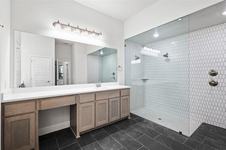 Full bathroom featuring vanity, a walk in shower, and dark marble finish flooring Full bathroom featuring vanity, a walk in shower, and dark marble finish flooring