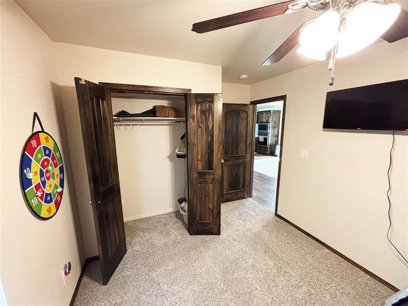 Bedroom featuring light colored carpet, a closet, and ceiling fan Bedroom featuring light colored carpet, a closet, and ceiling fan