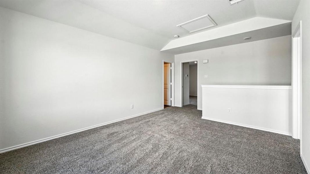 Spacious room featuring neutral carpeting, light-colored walls, and a white ceiling