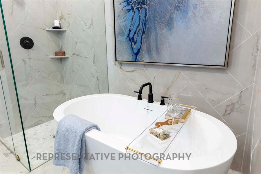 Bathroom with tile walls, a freestanding bath, and a shower stall Bathroom with tile walls, a freestanding bath, and a shower stall