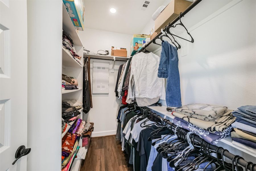 A second primary closet featuring ample storage shelves and sturdy wooden dowels, perfect for organizing and hanging clothing. A second primary closet featuring ample storage shelves and sturdy wooden dowels, perfect for organizing and hanging clothing.