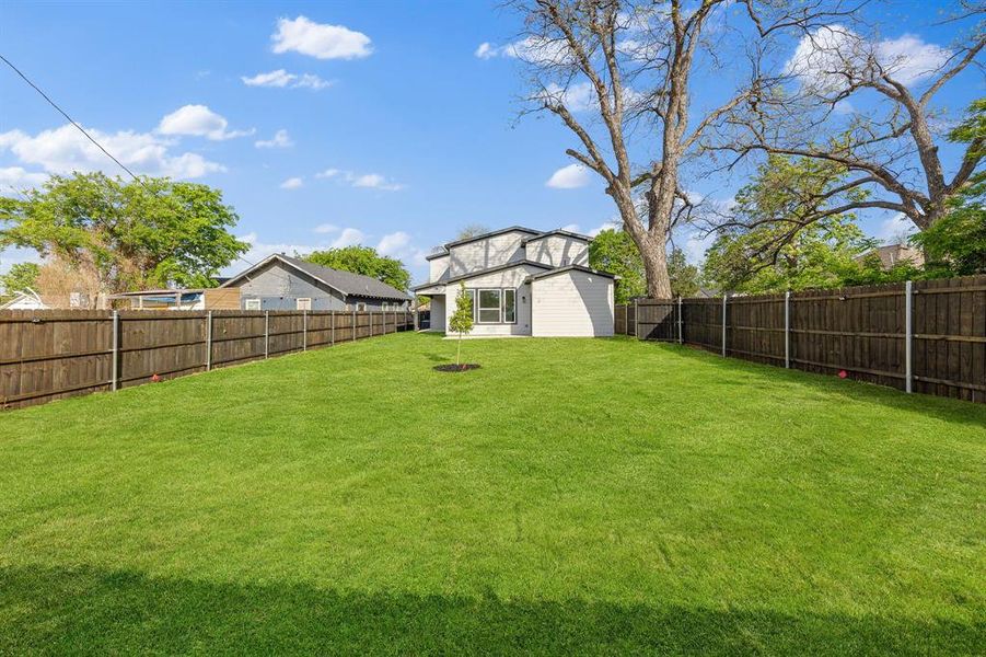 The property features an extensive, well-maintained lawn, enclosed by a wooden fence The property features an extensive, well-maintained lawn, enclosed by a wooden fence