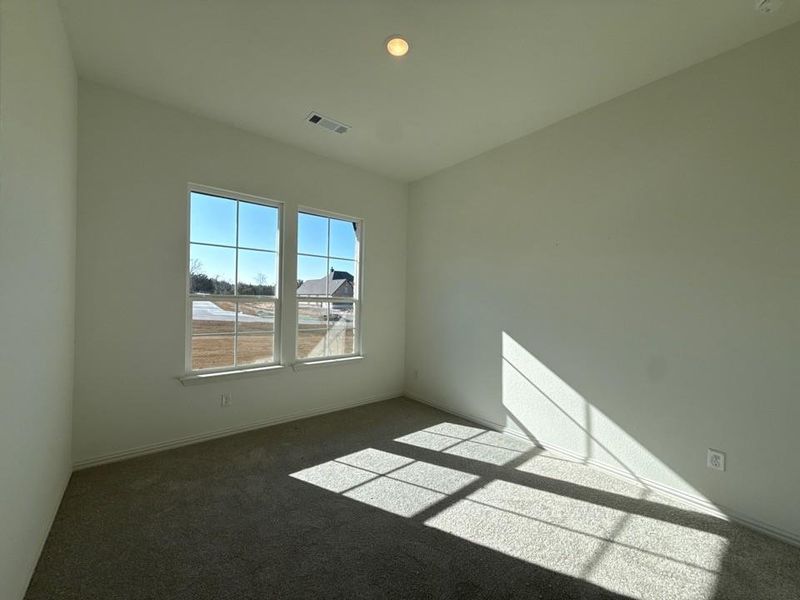 Empty room with dark carpet and baseboards