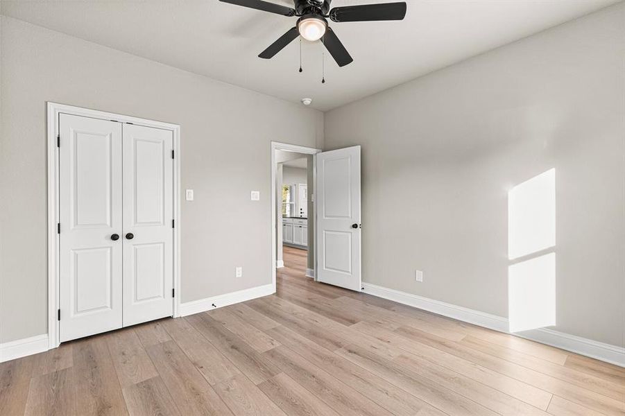 Unfurnished bedroom featuring light wood finished floors, a ceiling fan, and a closet Unfurnished bedroom featuring light wood finished floors, a ceiling fan, and a closet