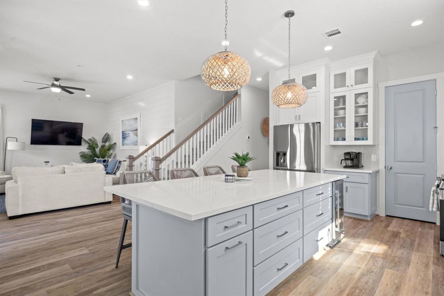 Looking from the island towards the living area, the space feels open and bright, with natural light flowing freely, creating a warm and inviting atmosphere.