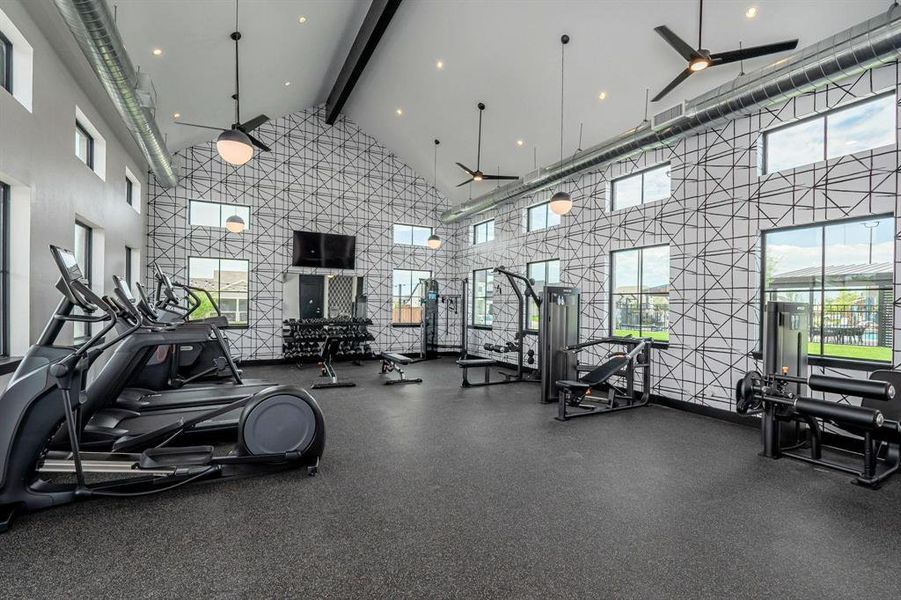 Workout area with ceiling fan and high vaulted ceiling