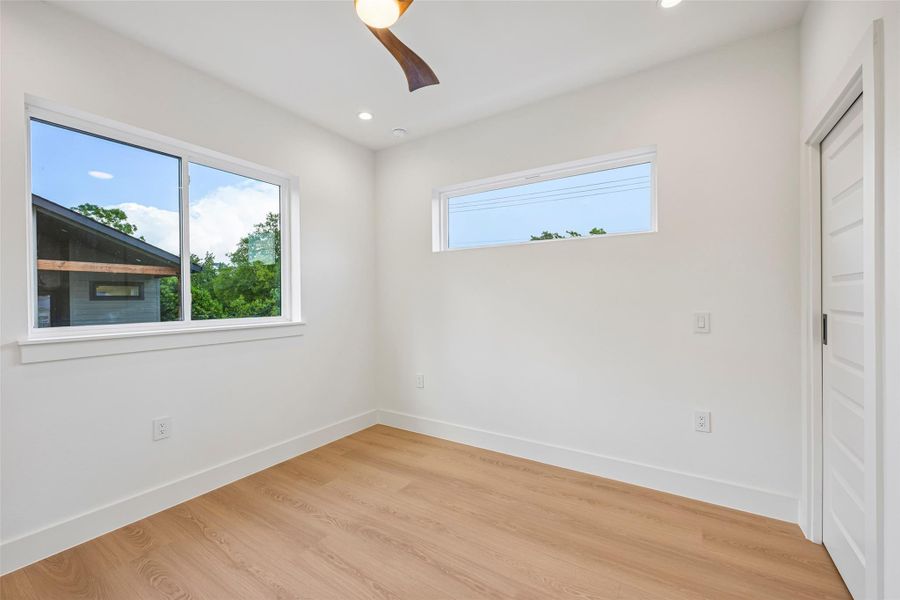 Natural light floods this secondary room, highlighting the clean lines and contemporary wood-look flooring.