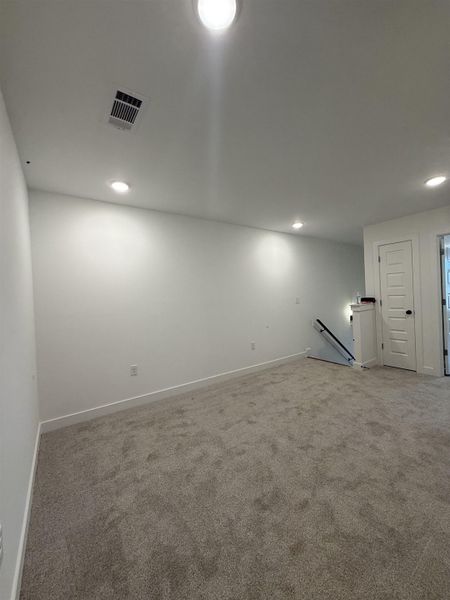 Carpeted spare room with baseboards and recessed lighting