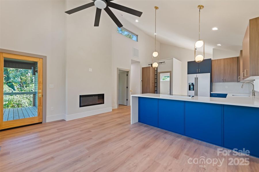 Great room with electric fireplace, bar style seating connecting the kitchen, an oversized fan to move the Smoky Mountain air and direct access to the upper porch