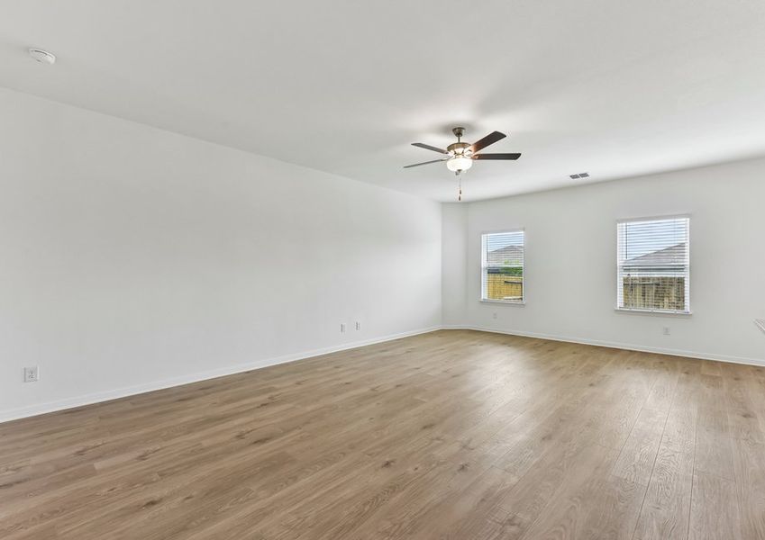 Family room featuring a ceiling fan, windows with natural light, and wood-look vinyl flooring.