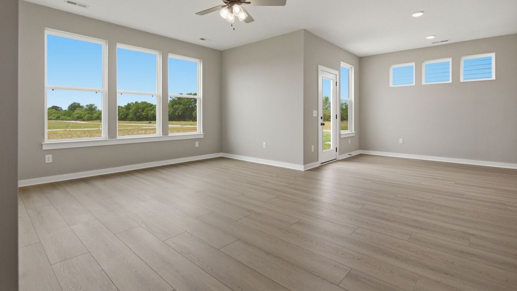Gathering and dining area with access to back entry and bright natural light through windows Gathering and dining area with access to back entry and bright natural light through windows