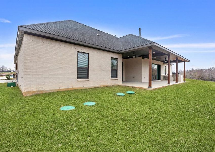 The Bradley II has a gorgeous back yard that includes a covered patio with an outdoor kitchen.