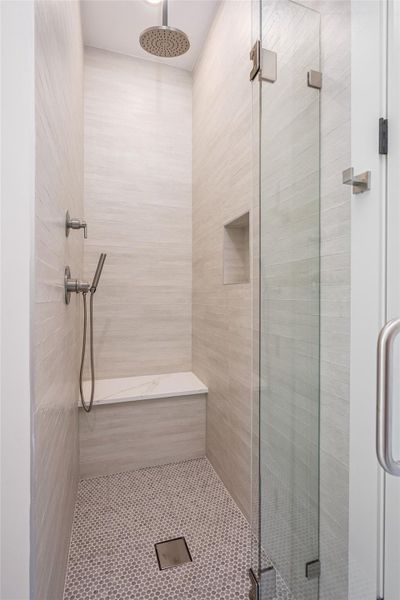 The onsite-designed porcelain wedge sink and spa-inspired walk-in shower with a built-in bench exude boutique hotel luxury The onsite-designed porcelain wedge sink and spa-inspired walk-in shower with a built-in bench exude boutique hotel luxury