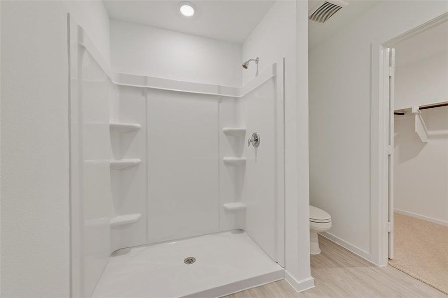 Bathroom featuring walk in shower, toilet, and hardwood / wood-style flooring