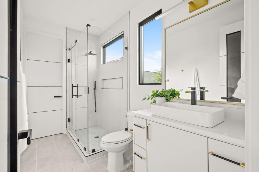 A well-appointed bath features a spacious glass-enclosed shower and a modern vanity with a vessel sink. A well-appointed bath features a spacious glass-enclosed shower and a modern vanity with a vessel sink.