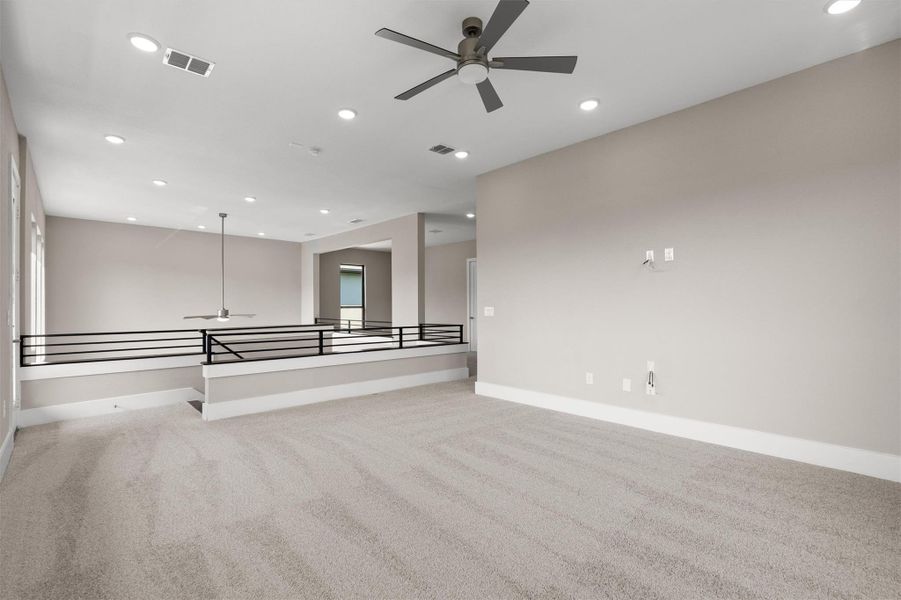 A spacious loft area offers versatility for various activities, highlighted by modern lighting and an open railing. A spacious loft area offers versatility for various activities, highlighted by modern lighting and an open railing.