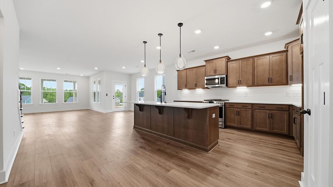 Superior kitchen with quartz countertops, pendant lighting, and a generously sized island located in Moore, SC