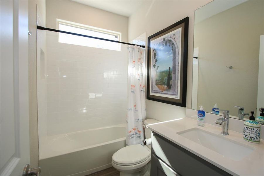 Guest bathroom with tub/shower combo and vanity