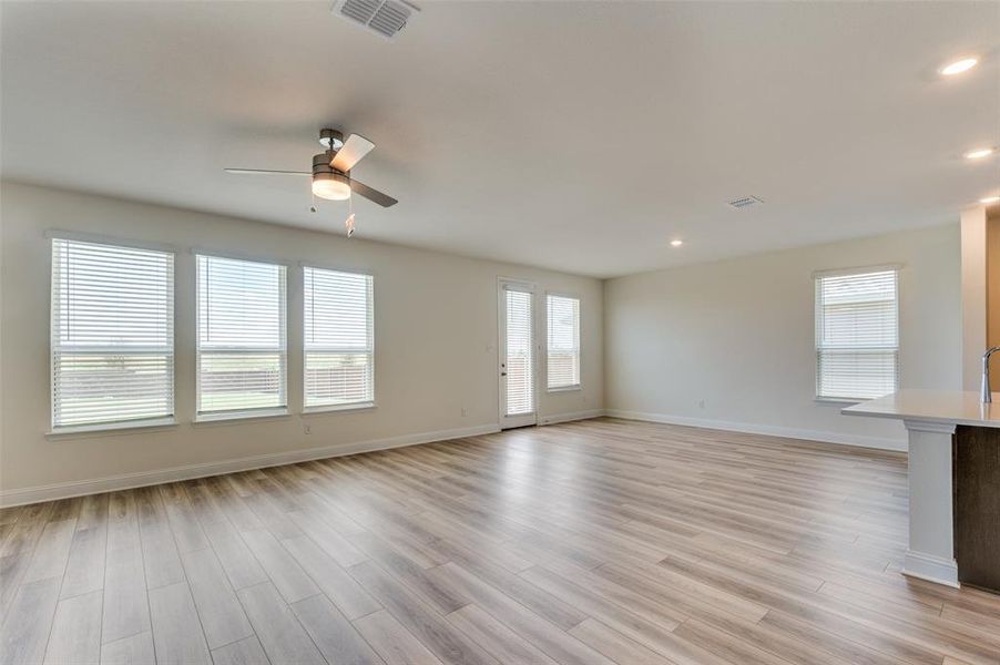 Unfurnished living room featuring a ceiling fan, light wood-type flooring, healthy amount of natural light, and recessed lighting