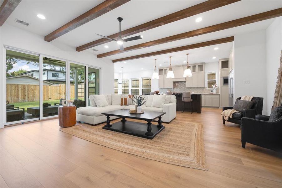 Living room featuring recessed lighting, light wood-style floors, beam ceiling, and a ceiling fan Living room featuring recessed lighting, light wood-style floors, beam ceiling, and a ceiling fan