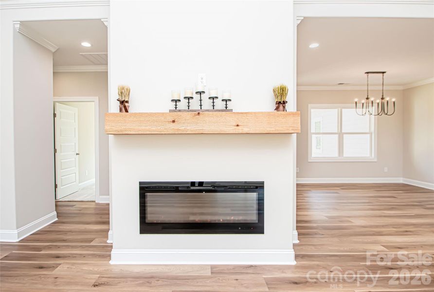 Beautifully appointed electric fireplace with elegant mantle serves as the focal point of the family room.