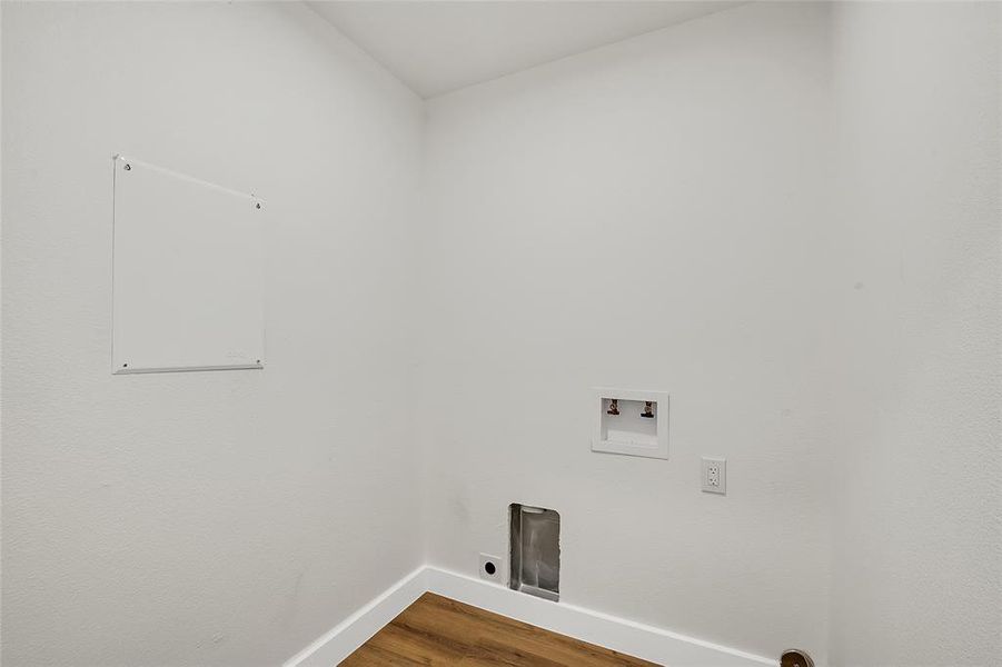 Laundry area with wood-style flooring and hookup for a washing machine