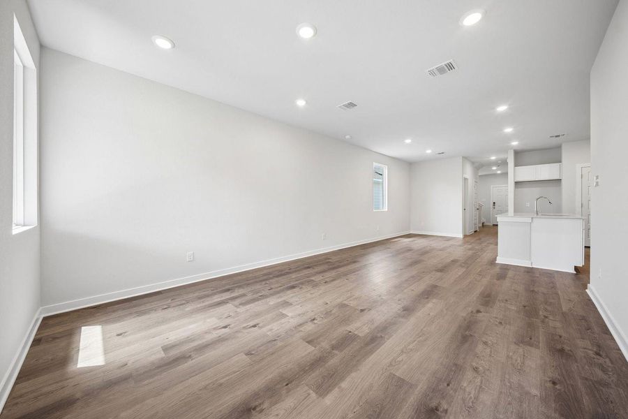 Recessed lighting and warm wood flooring define this versatile open-concept living space. Recessed lighting and warm wood flooring define this versatile open-concept living space.