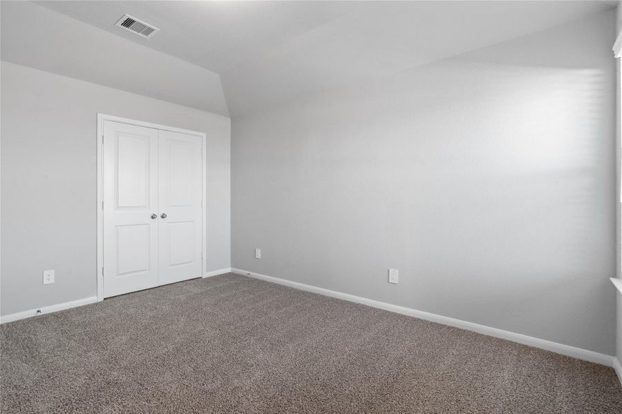 Perfect for guests or a quiet home office, this room features soft plush carpeting, a window with fitted blinds, sloped ceiling, and ample sized closet space.