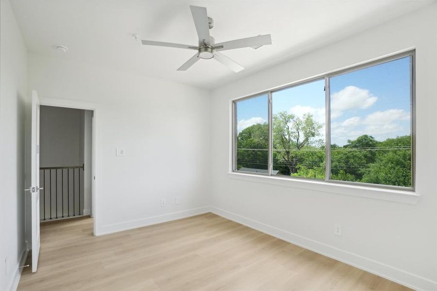 Unfurnished bedroom featuring light wood-style flooring, baseboards, and ceiling fan