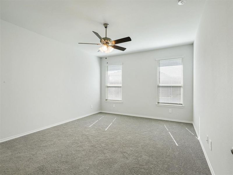 Spare room with baseboards, a ceiling fan, and carpet floors Spare room with baseboards, a ceiling fan, and carpet floors