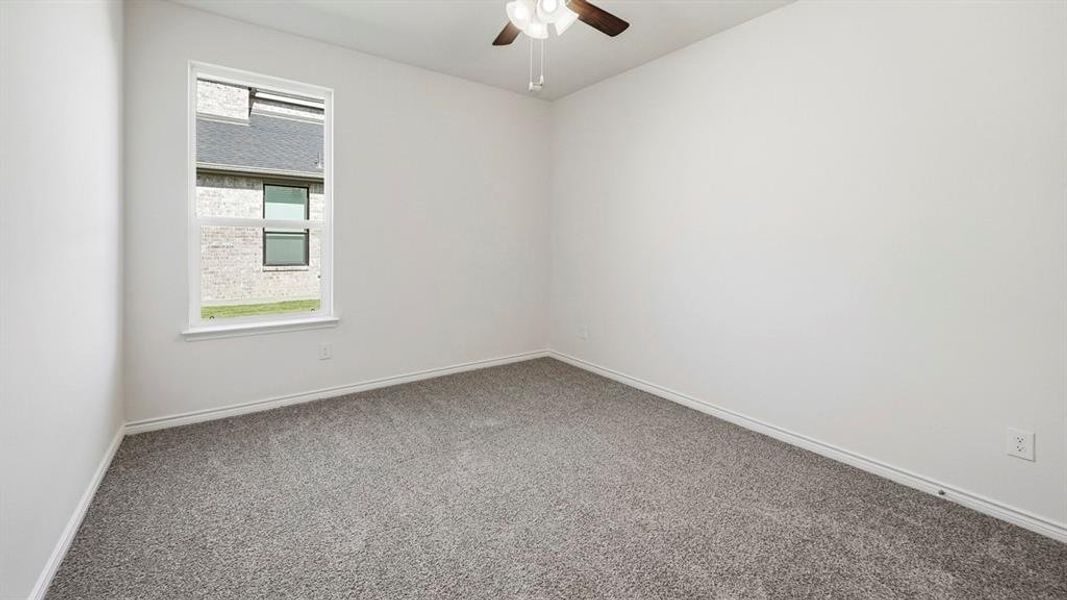 Empty room with carpet floors and ceiling fan