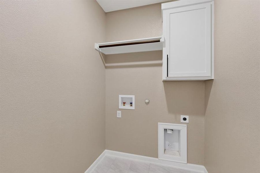 Laundry area with gas dryer hookup, electric dryer hookup, hookup for a washing machine, light tile patterned flooring, and cabinet space Laundry area with gas dryer hookup, electric dryer hookup, hookup for a washing machine, light tile patterned flooring, and cabinet space