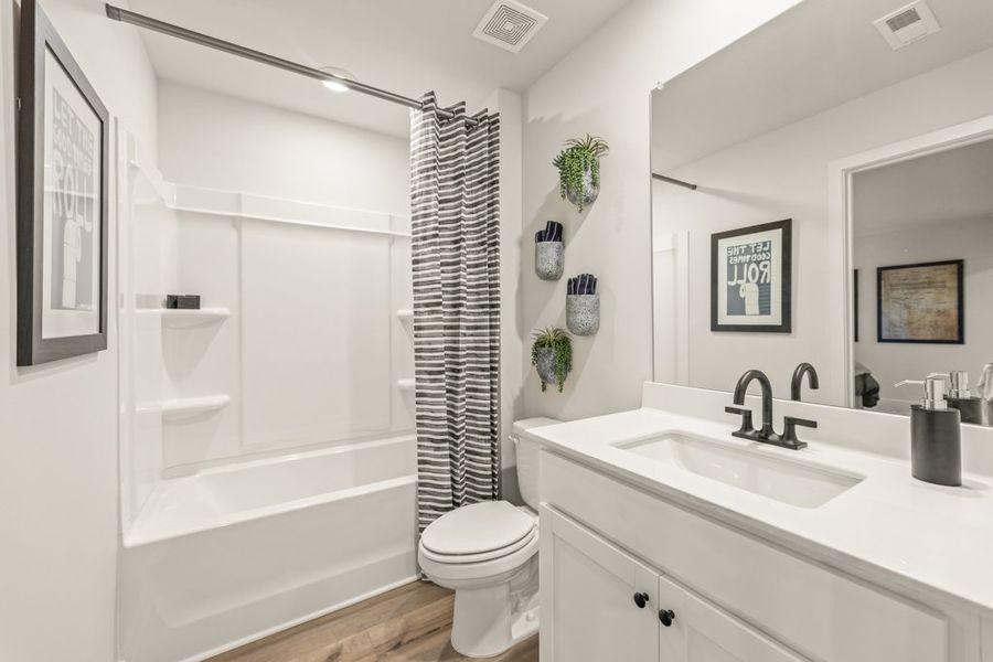 A bathroom with a tub sink and toilet.
