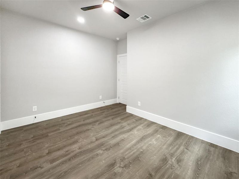 Unfurnished room with dark wood-style flooring and ceiling fan