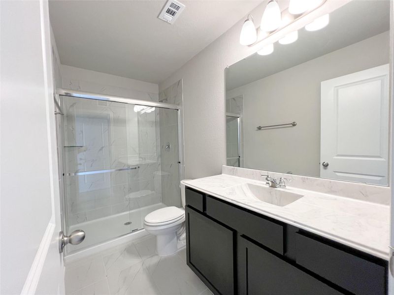 Full bathroom with a shower stall, visible vents, toilet, and vanity Full bathroom with a shower stall, visible vents, toilet, and vanity