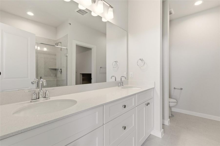 Bathroom with recessed lighting, double vanity, a shower stall, and light tile patterned floors