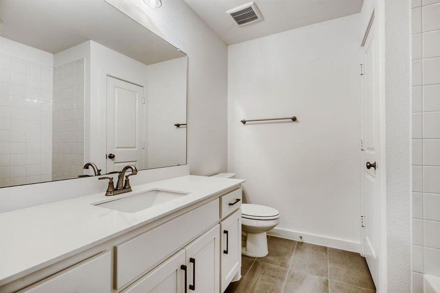 Bathroom featuring vanity, a shower, and light tile patterned floors