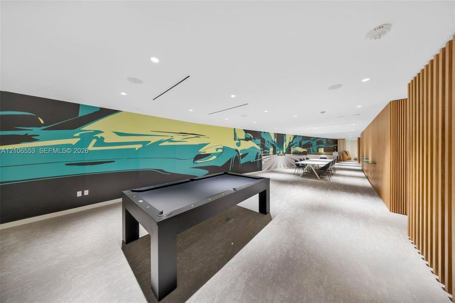 Large-scale graphic wall mural, recessed ceiling lighting, textured wood-slat wall paneling, and neutral flooring