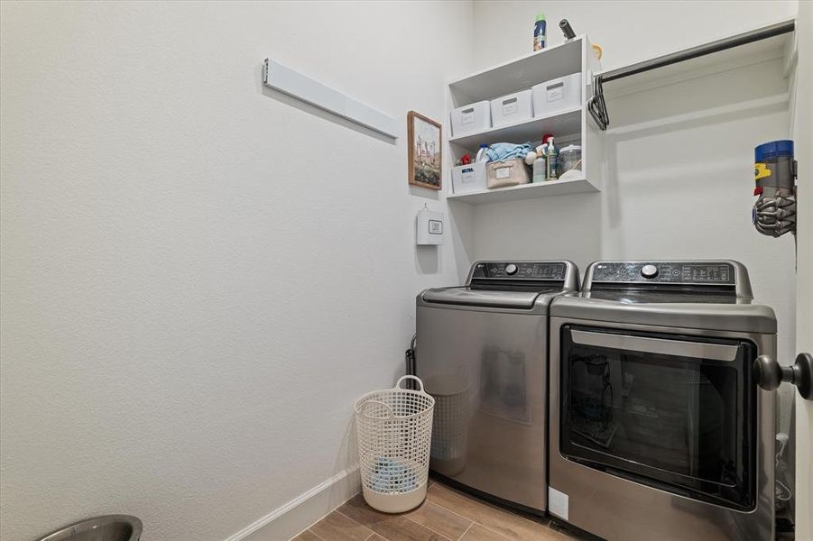 Laundry room with independent washer and dryer and wood finished floors Laundry room with independent washer and dryer and wood finished floors