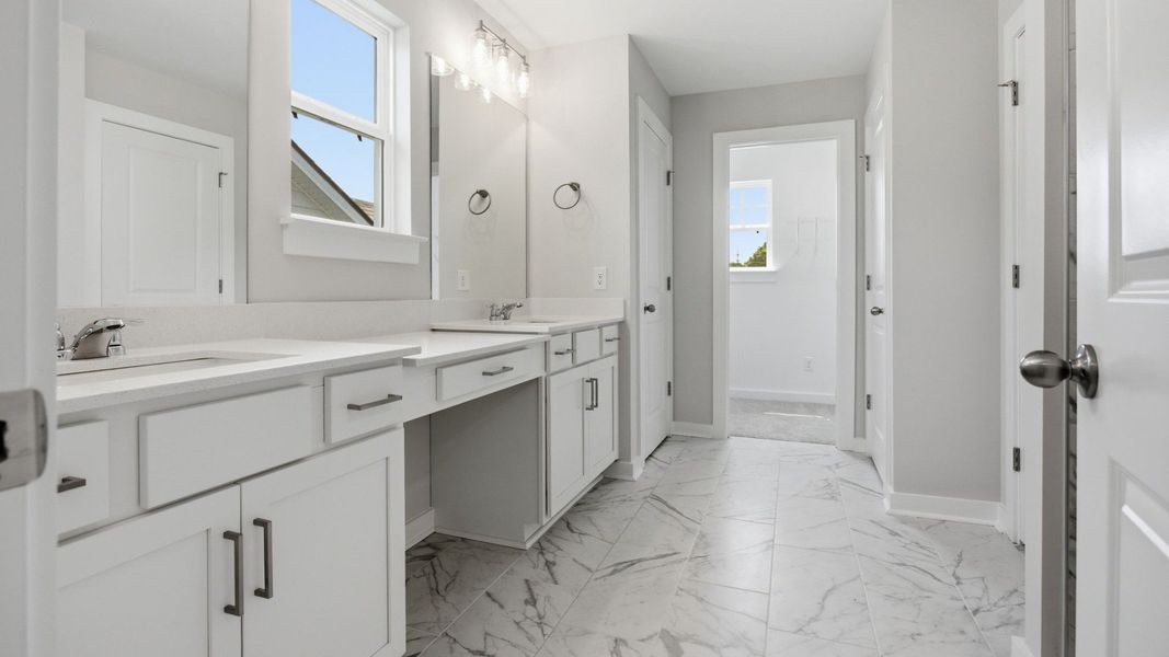 Bathroom with access to closet, dual vanity, and window Bathroom with access to closet, dual vanity, and window