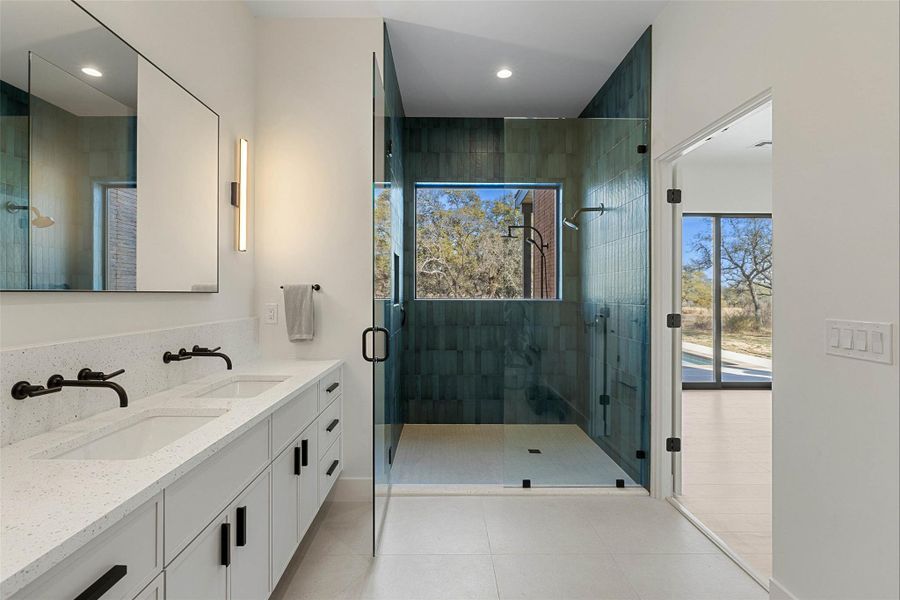 Full bath with a shower stall, double vanity, light tile patterned flooring, and recessed lighting