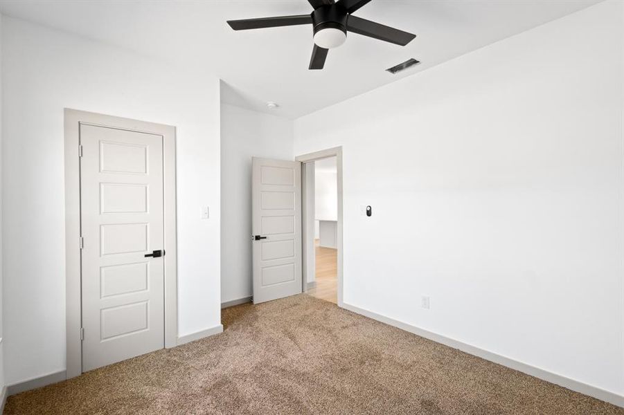 Unfurnished bedroom featuring carpet, visible vents, baseboards, and ceiling fan Unfurnished bedroom featuring carpet, visible vents, baseboards, and ceiling fan