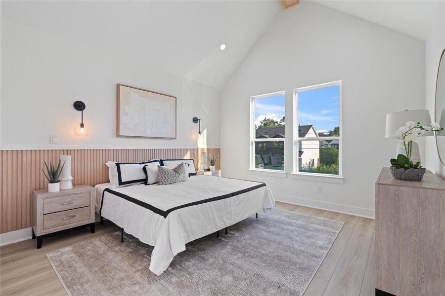 The primary bedroom impresses with vaulted ceilings and a striking wood beam that perfectly complements the fluted wood accent wall behind the bed, echoing the design of the secondary living area. This harmonious blend of textures and architectural details creates a serene, luxurious retreat. With its spacious layout and thoughtful design, it’s a place to unwind, recharge, and truly feel at home.