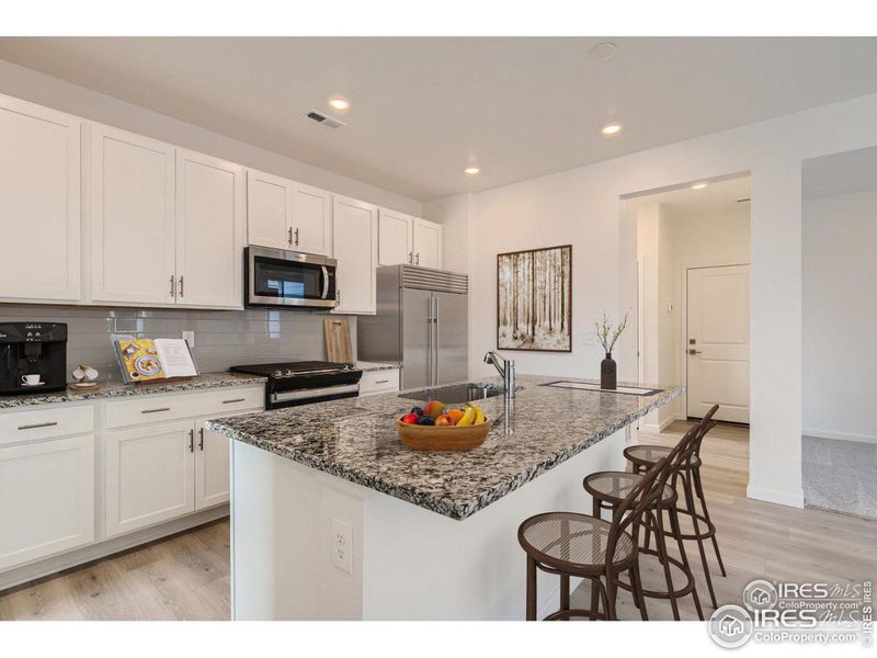 Granite island with lots of soft close cabinets & stainless steel appliances. Virtually staged and the refrigerator is not included.