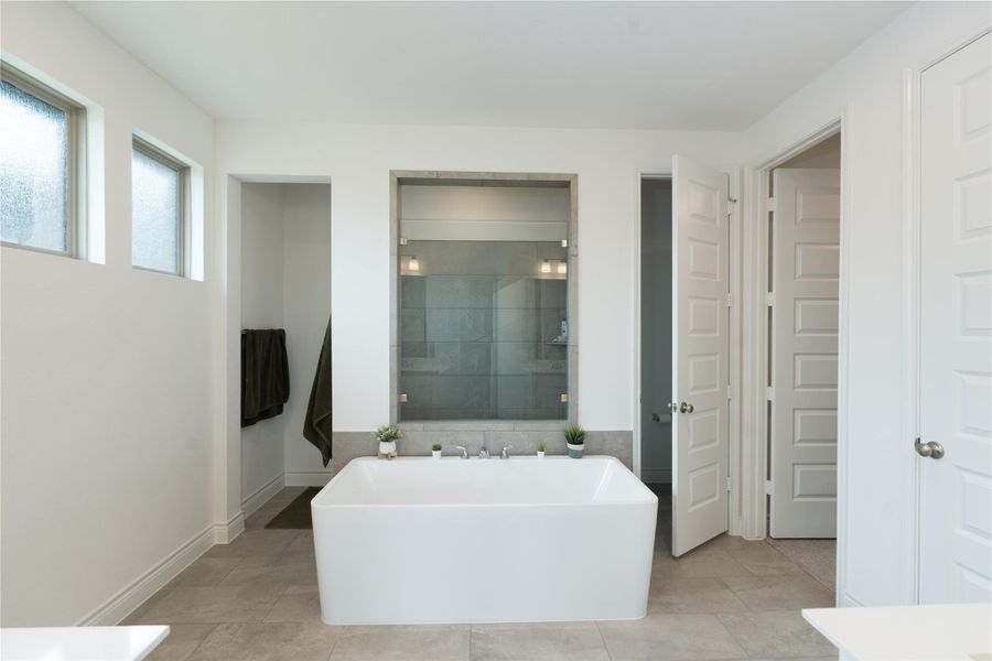 Bathroom with a stall shower, a soaking tub, vanity, and light tile patterned floors