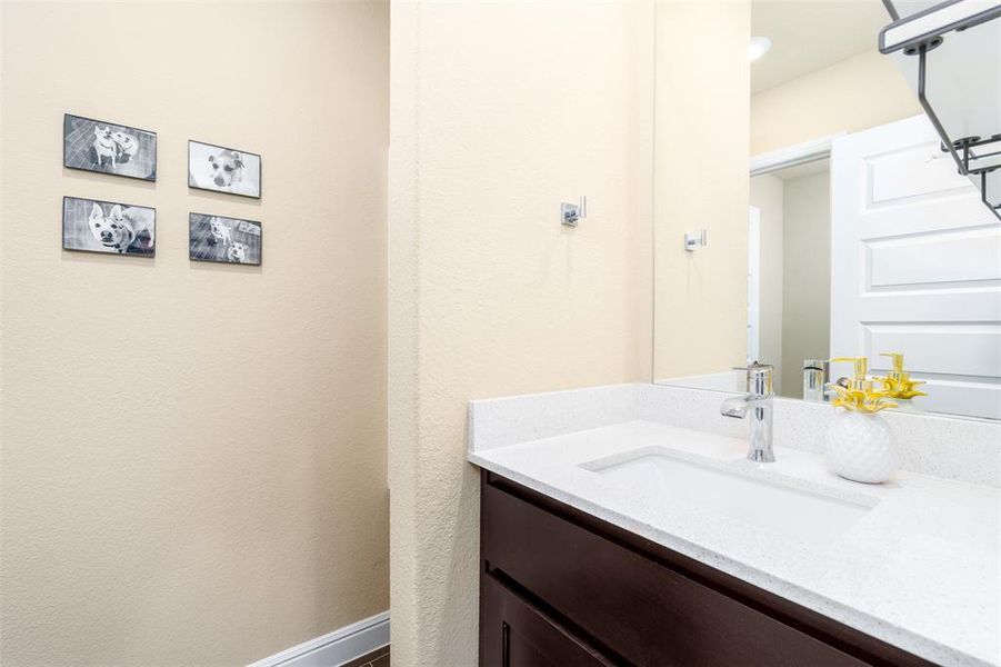 Hall bathroom has two sections. The first is open linen shelves and storage with a large vanity shown here.