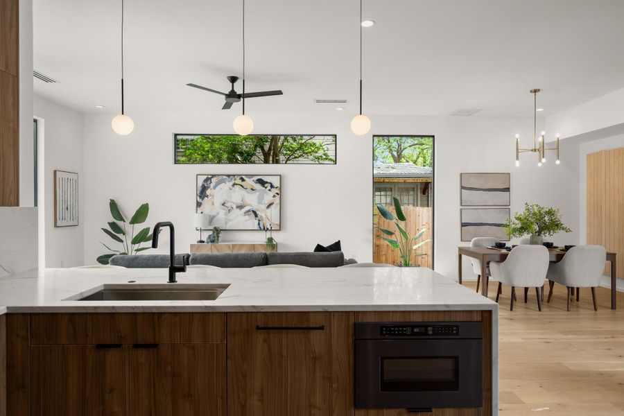 Kitchen featuring light stone counters, a peninsula, modern cabinets, and black oven