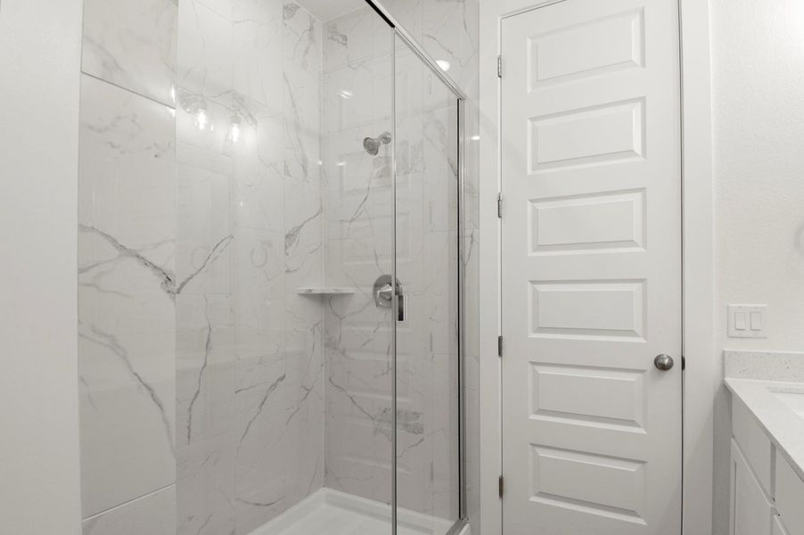Bathroom with vanity and a marble finish shower